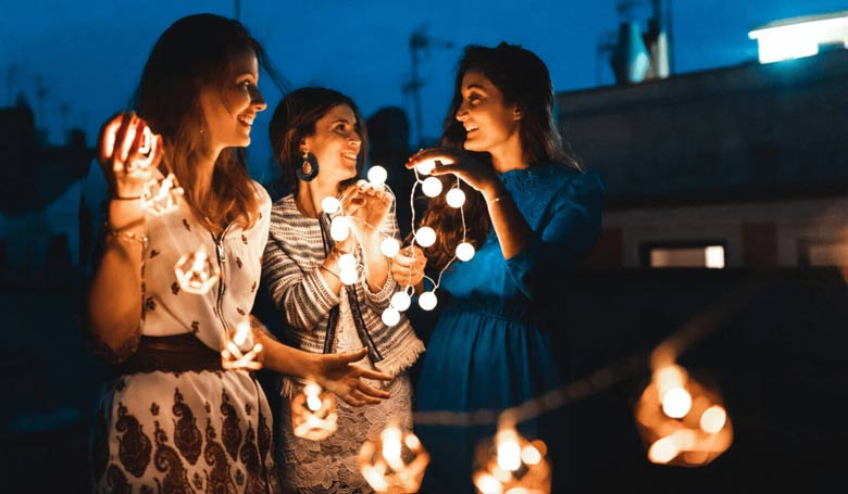 Femmes tenant des lumières tendances pour embellir leur extérieur